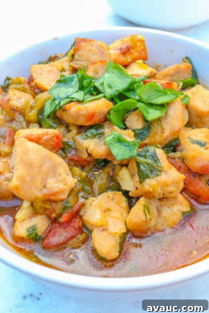 A beautifully presented bowl of Colorado Pork Green Chile with spinach, showcasing the rich texture and vibrant colors of the stew, ready to be enjoyed.