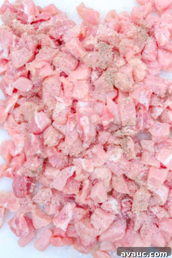 Perfectly diced, raw pork prepared for the Colorado green chile stew, ready for seasoning and browning.