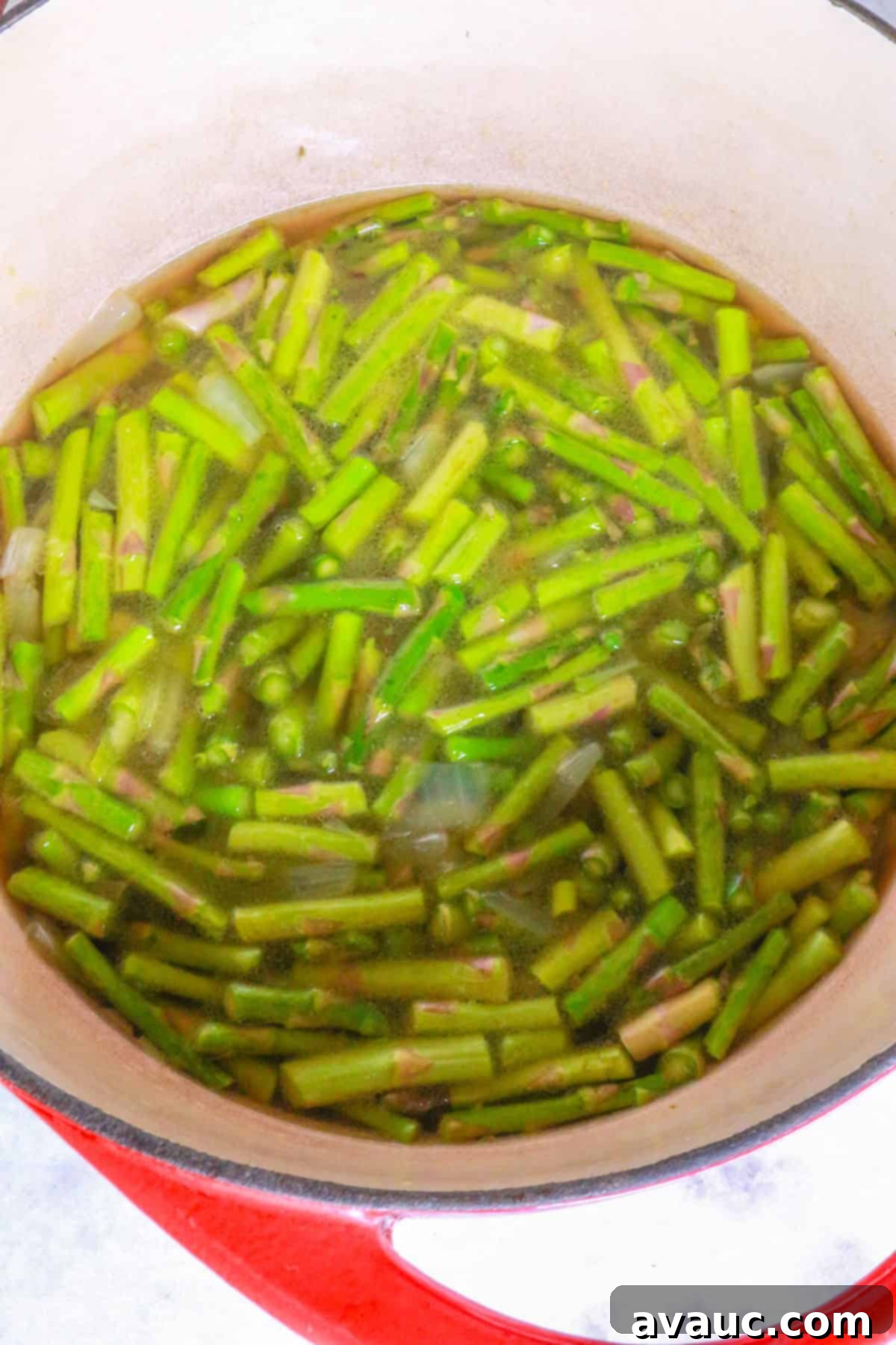 Creamy Dairy-Free Asparagus Soup 5 Pot with simmering asparagus pieces in broth