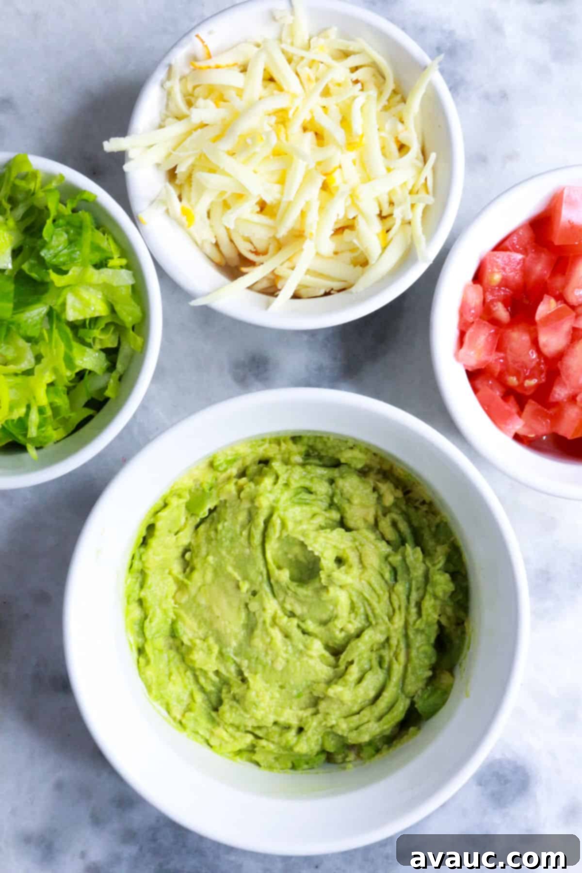 Delicious Avocado Tostadas 4 Containers filled with shredded lettuce, crumbled cheese, mashed avocado, and diced tomatoes, perfectly prepped for tostada assembly.