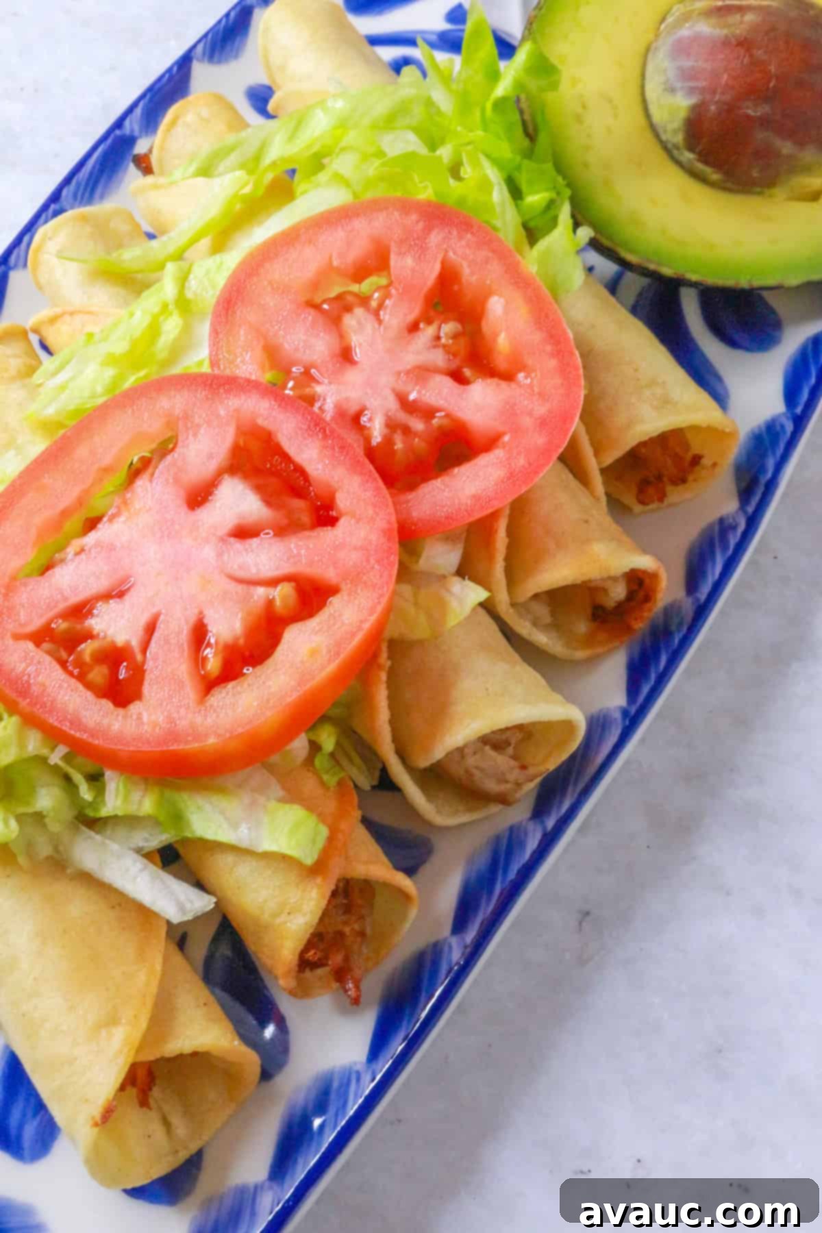 Pork Flautas topped with lettuce and tomato