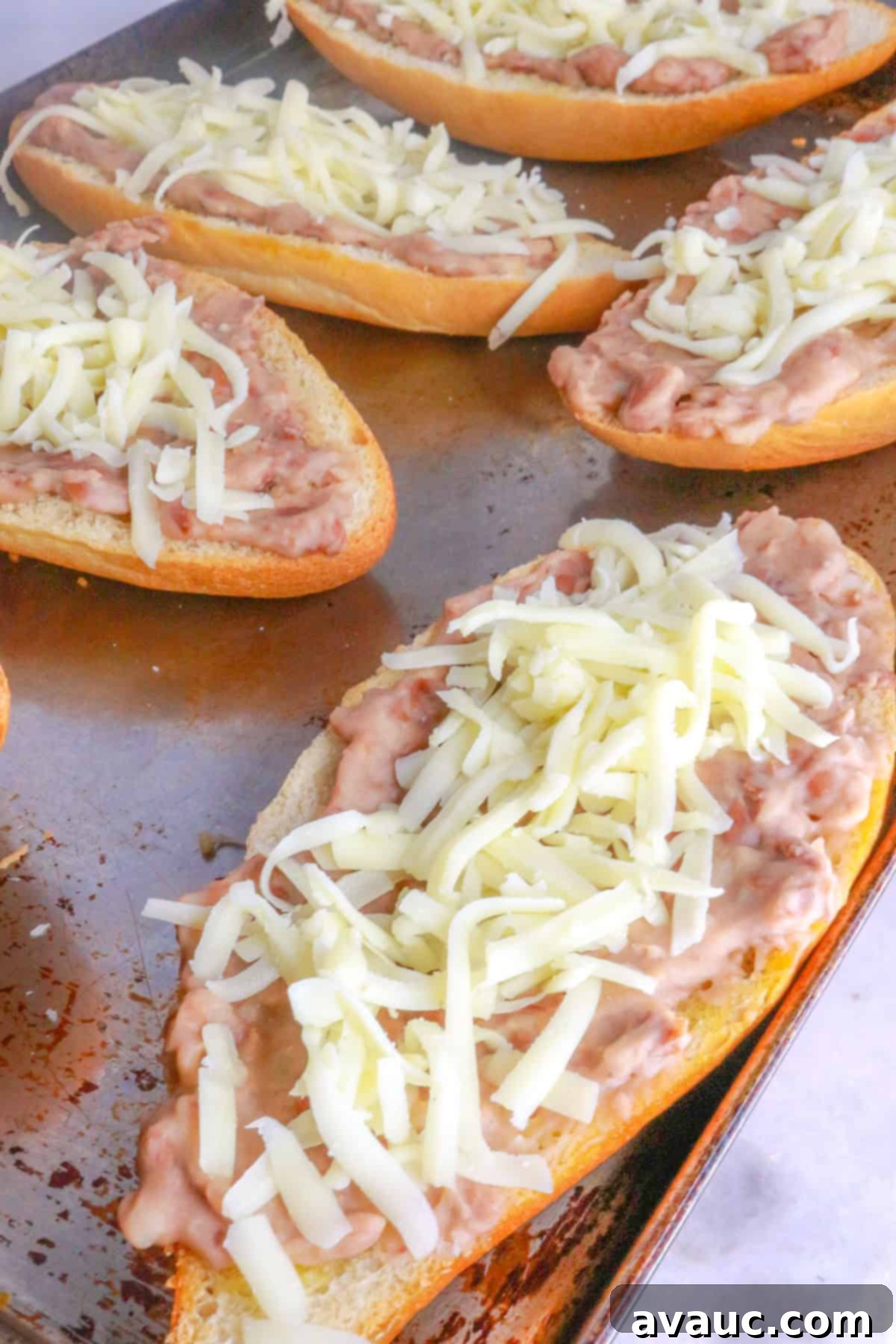 Homemade Mexican Molletes 9 Molletes assembled with beans and cheese, ready for the oven