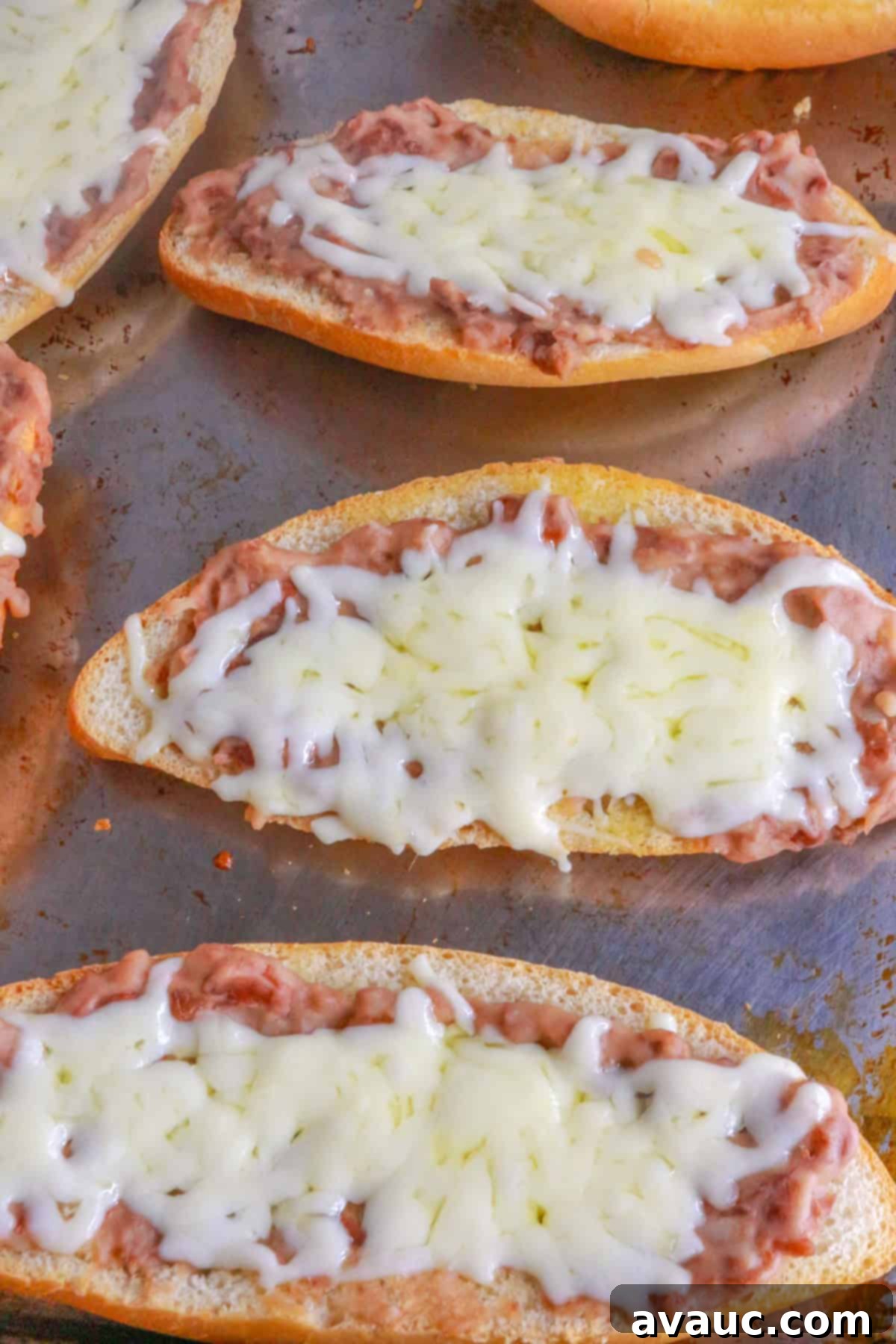 Homemade Mexican Molletes 10 Molletes baking on a sheet pan in the oven