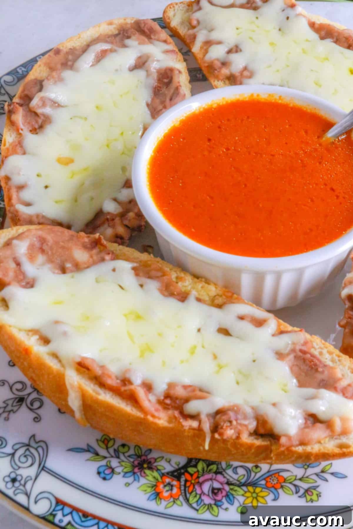 Homemade Mexican Molletes 2 Cheesy molletes Mexicanos on a plate with a bowl of chipotle sauce in the middle, ready to be served