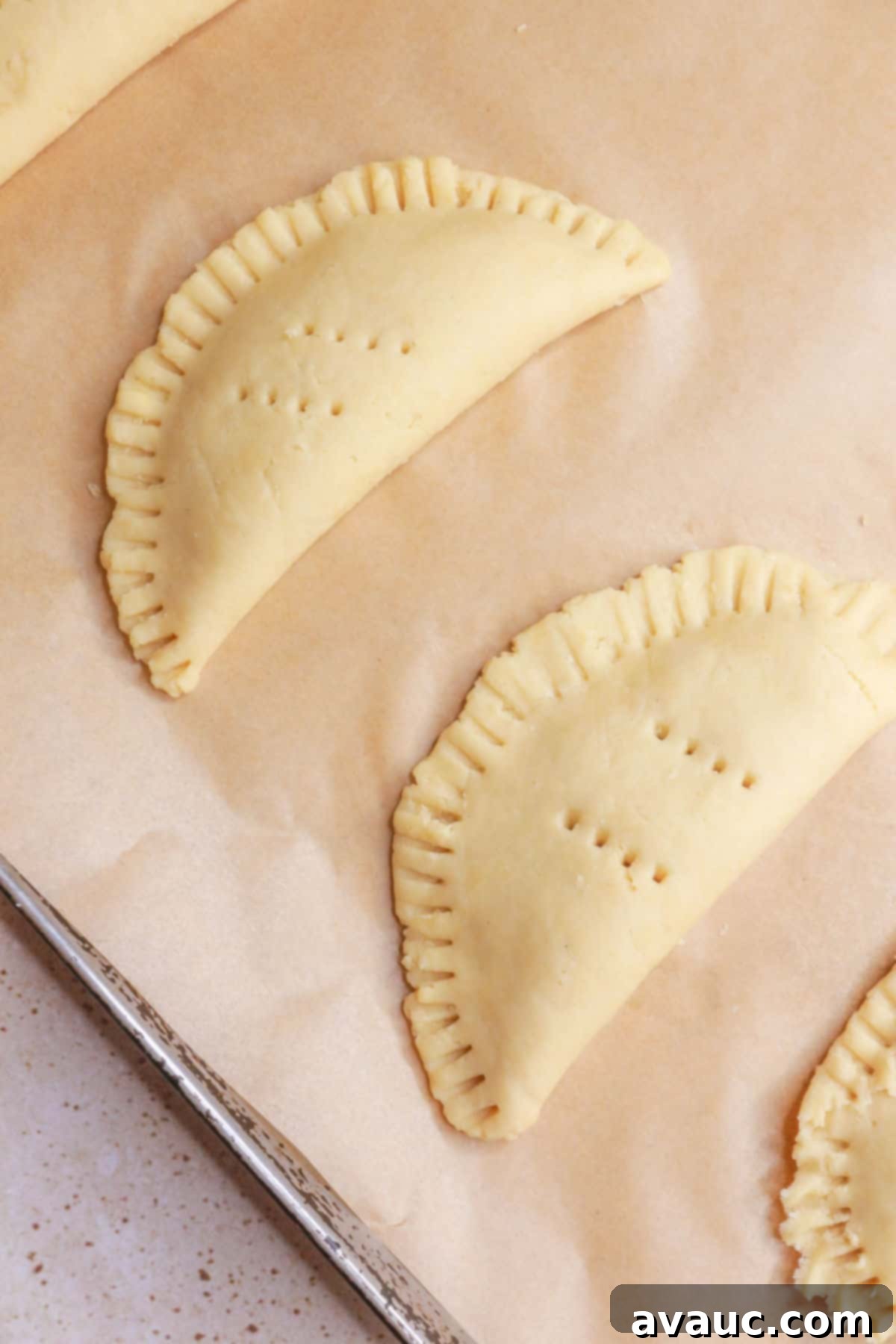 Delightful Gluten-Free Pineapple Empanadas 13 Empanadas arranged on parchment paper, ready for baking