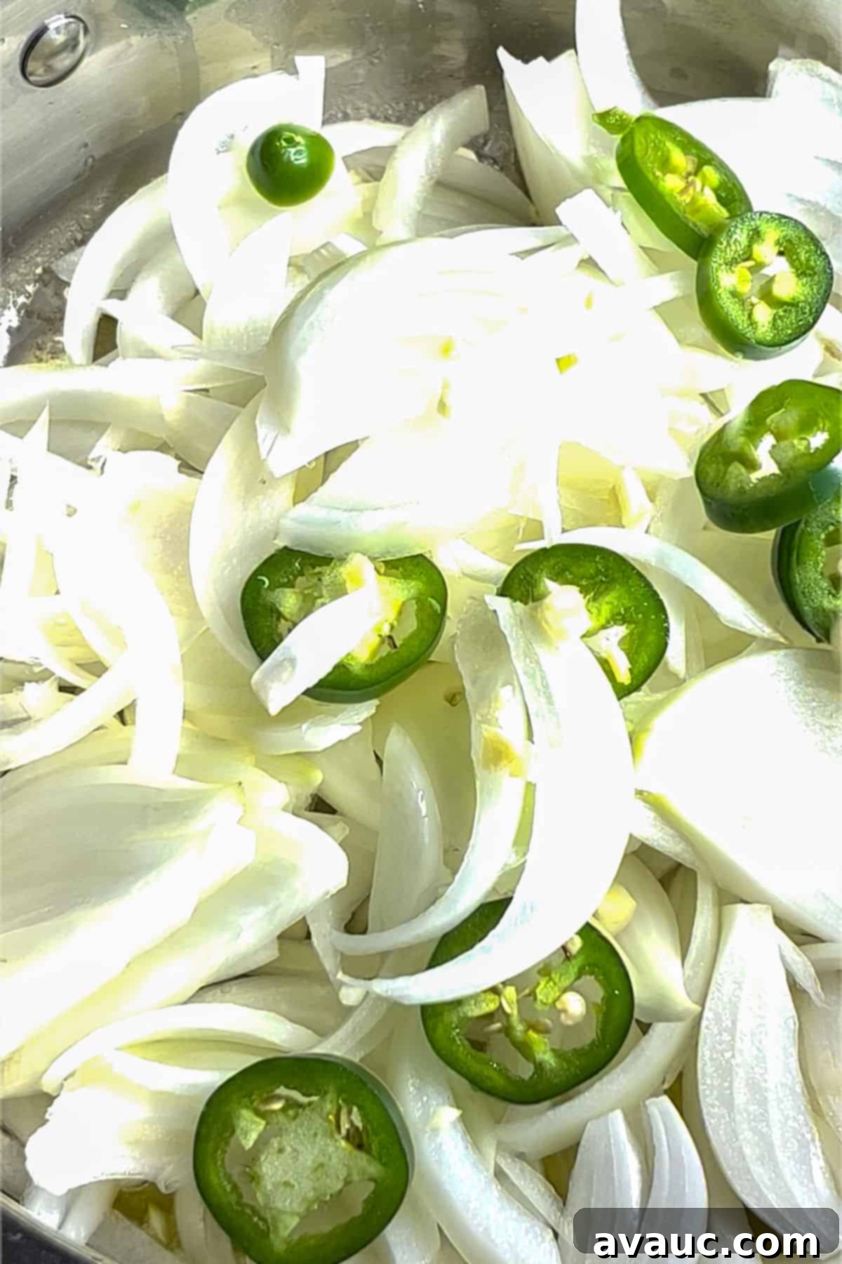 Sautéing onions, jalapeños, and garlic in butter in a pan until soft and fragrant.