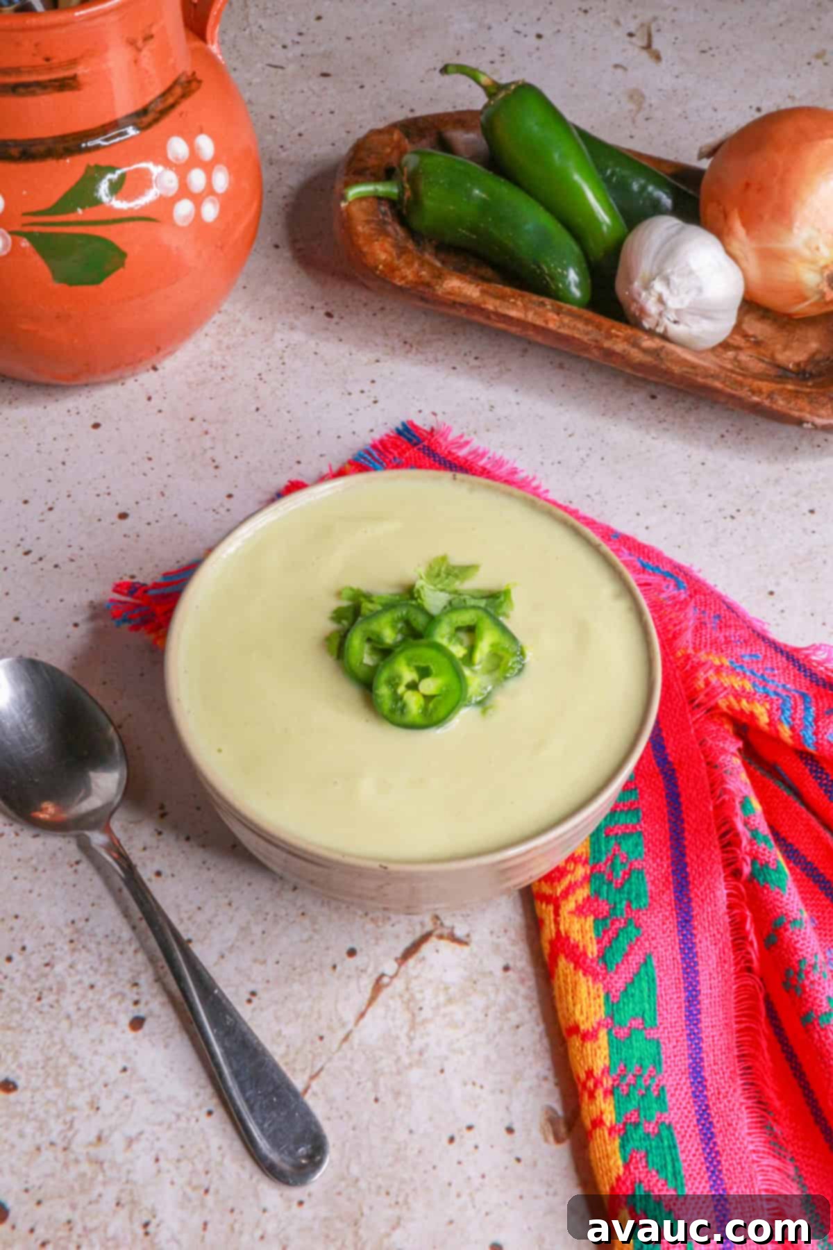 Cream of Onion Soup with Jalapeño in a white bowl, garnished with cilantro and sliced jalapeños.